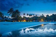 Tropical beach with palm trees and resort lights at night, Bintan island Tropical beach with palm trees and resort lights at night, Bintan island